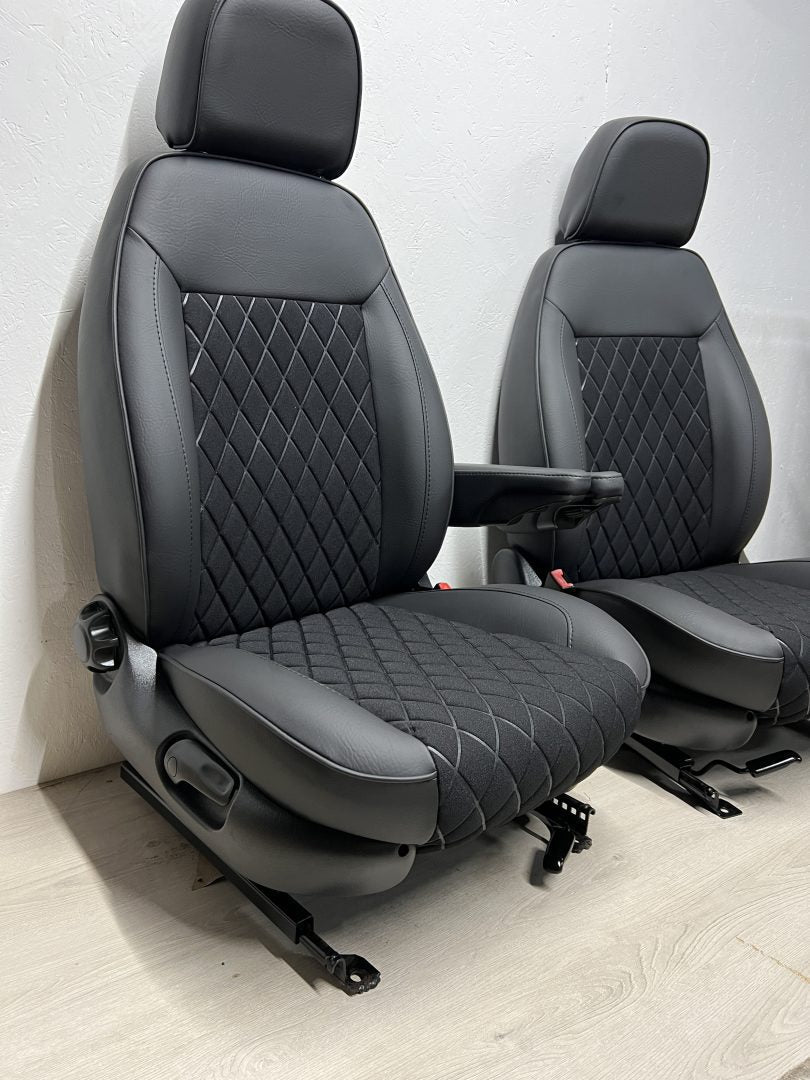 Pair of MK2 Swivel Replacement Captain Seats, side view highlighting matt black leatherette, black faux centre panels with Bentley stitching, and armrests.