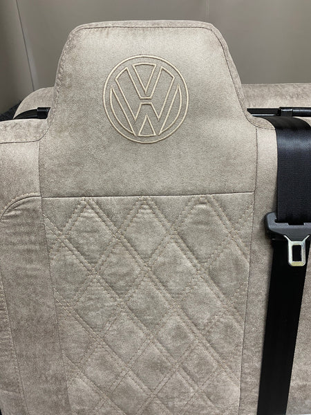 Rock & Roll Bed M1 Tested 3/4 Width, close-up of upper backrest in beige faux suede with Bentley stitching and embroidered VW logo.