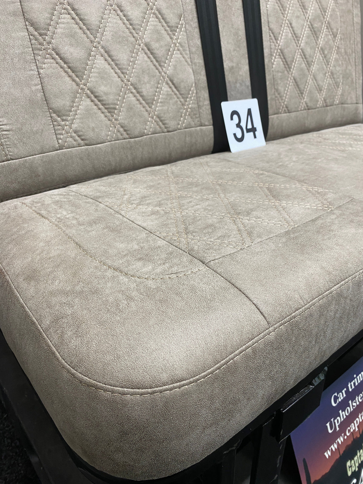 Rock & Roll Bed M1 Tested 3/4 Width, close-up of beige faux suede seat base with Bentley cross stitching.