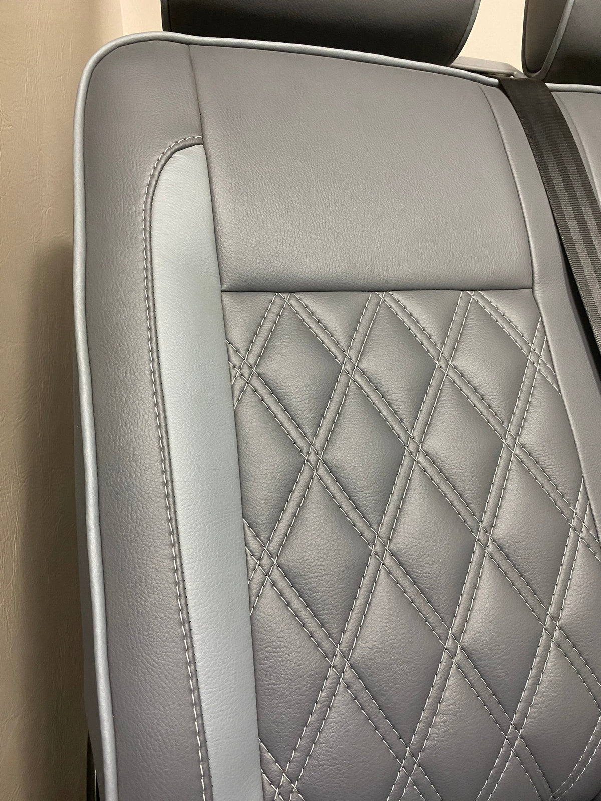 VW Factory Front Seats T5 T6, close-up of seat back with light grey leatherette insert and white Bentley cross stitching.