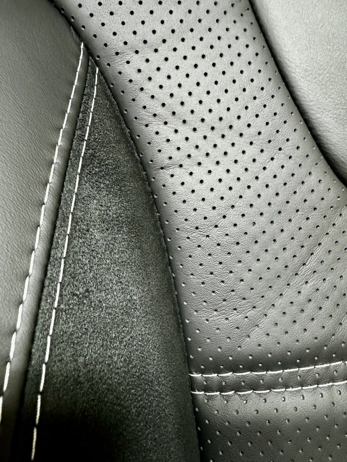 Close-up of VW T5 T6 Factory Front Seat Wing Back showing perforated leather centre panel, Alcantara inserts, and light grey stitching.