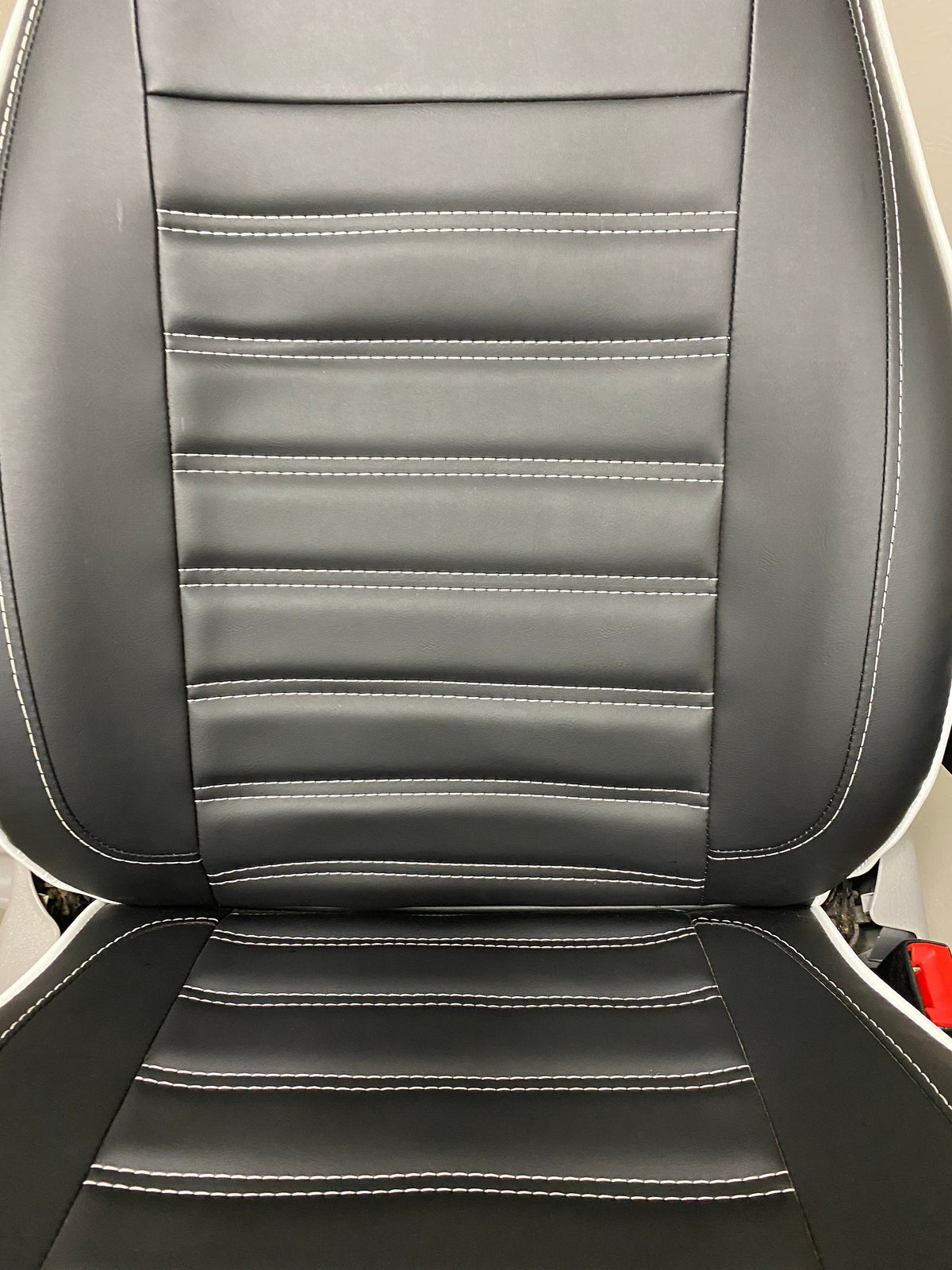 MK1 Replacement Swivel Captain Seat, close-up of seat back with horizontal white stitching on black leatherette.