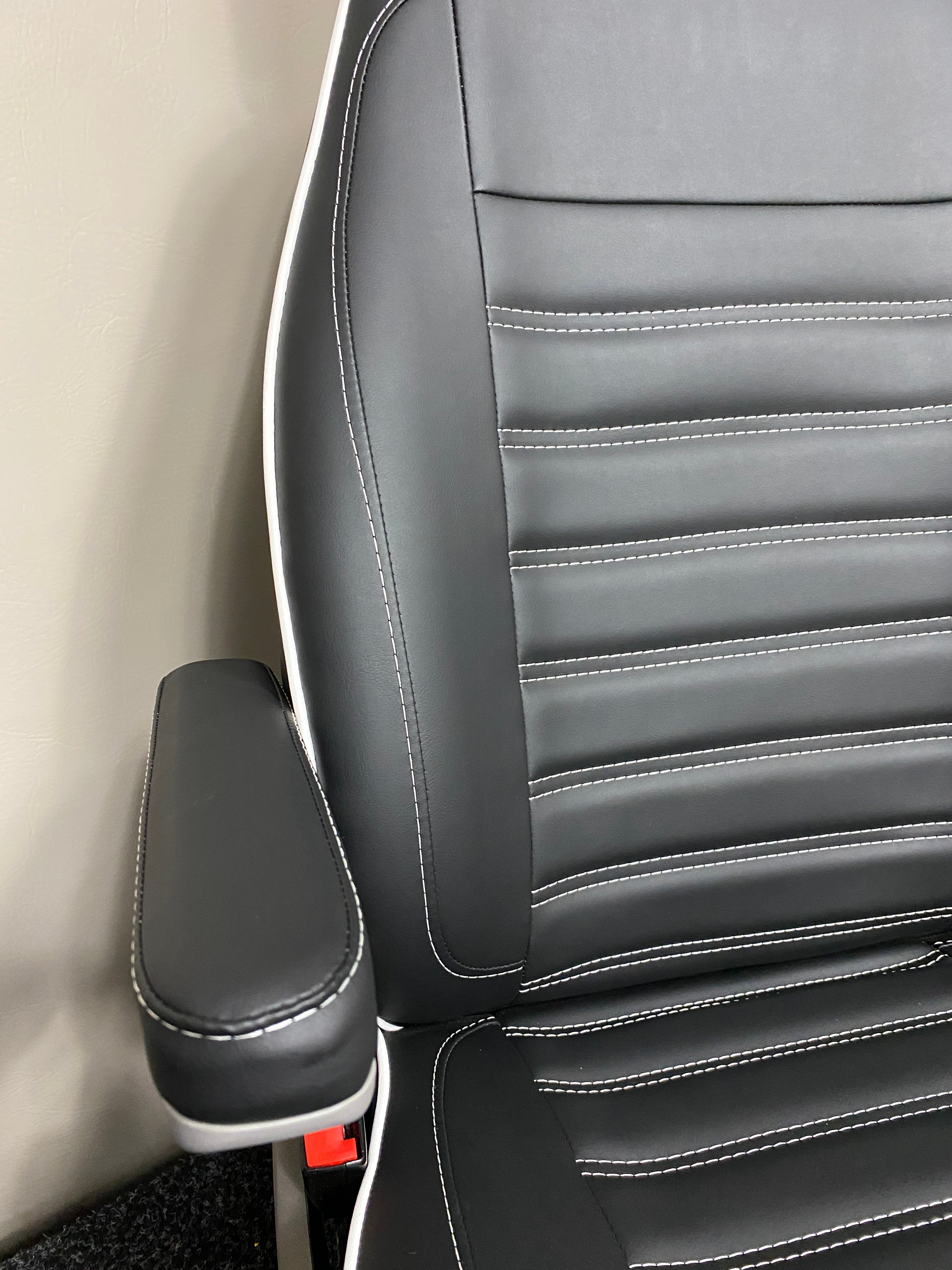 MK1 Replacement Swivel Captain Seat featuring a single armrest, horizontal white stitching and white piping on black leatherette upholstery.