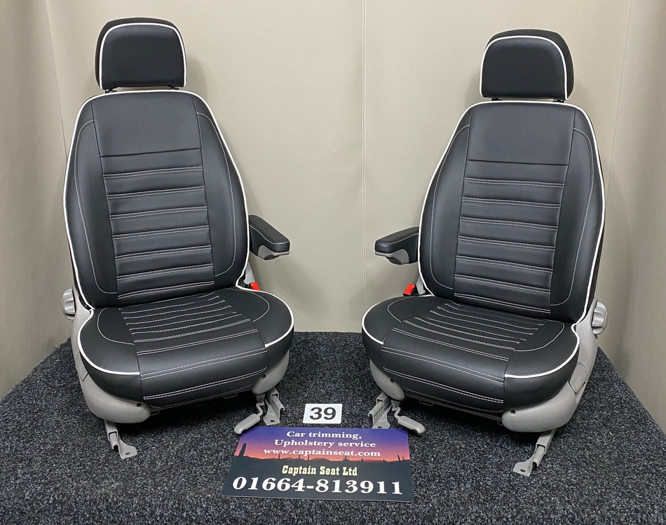 MK1 Replacement Swivel Captain Seats in black leatherette featuring wide horizontal white stitching and white piping, light grey plastic trim and one armrest per seat.