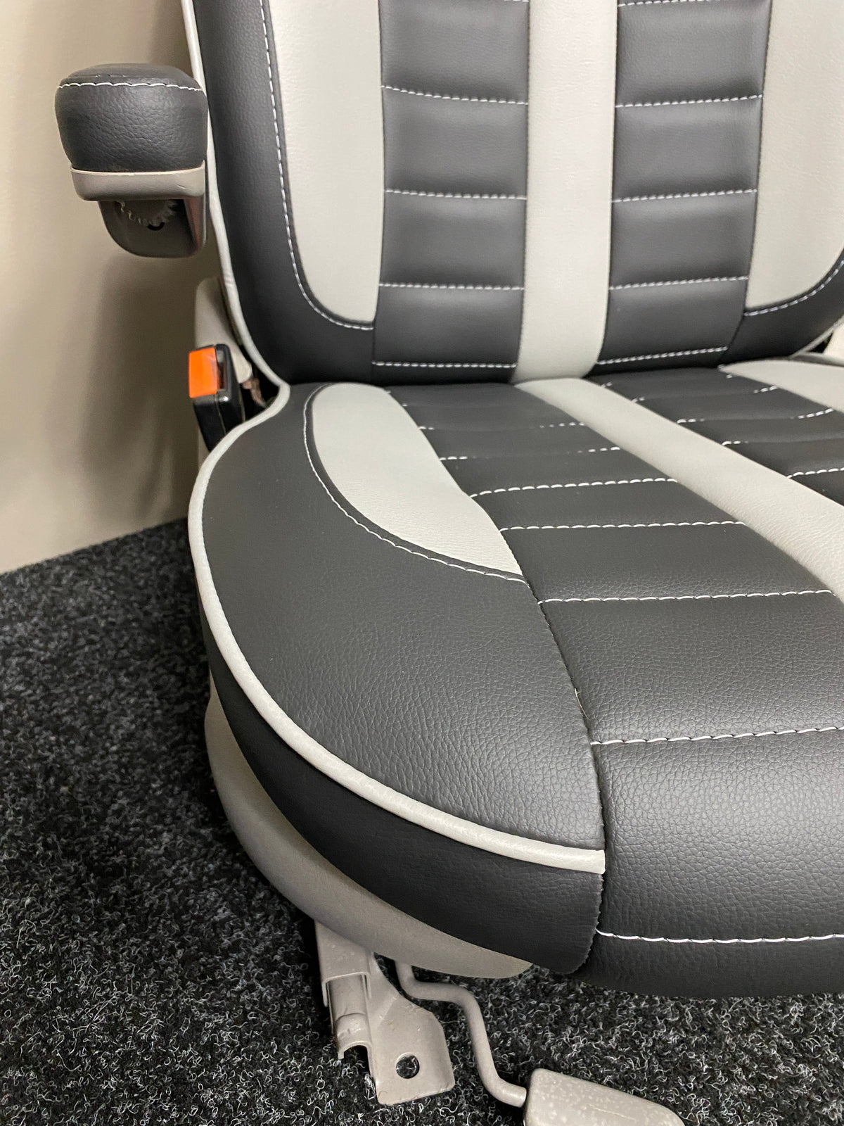 MK1 Replacement Swivel Captain Seat close-up of black leatherette, grey inserts, grey piping, and horizontal stitching.