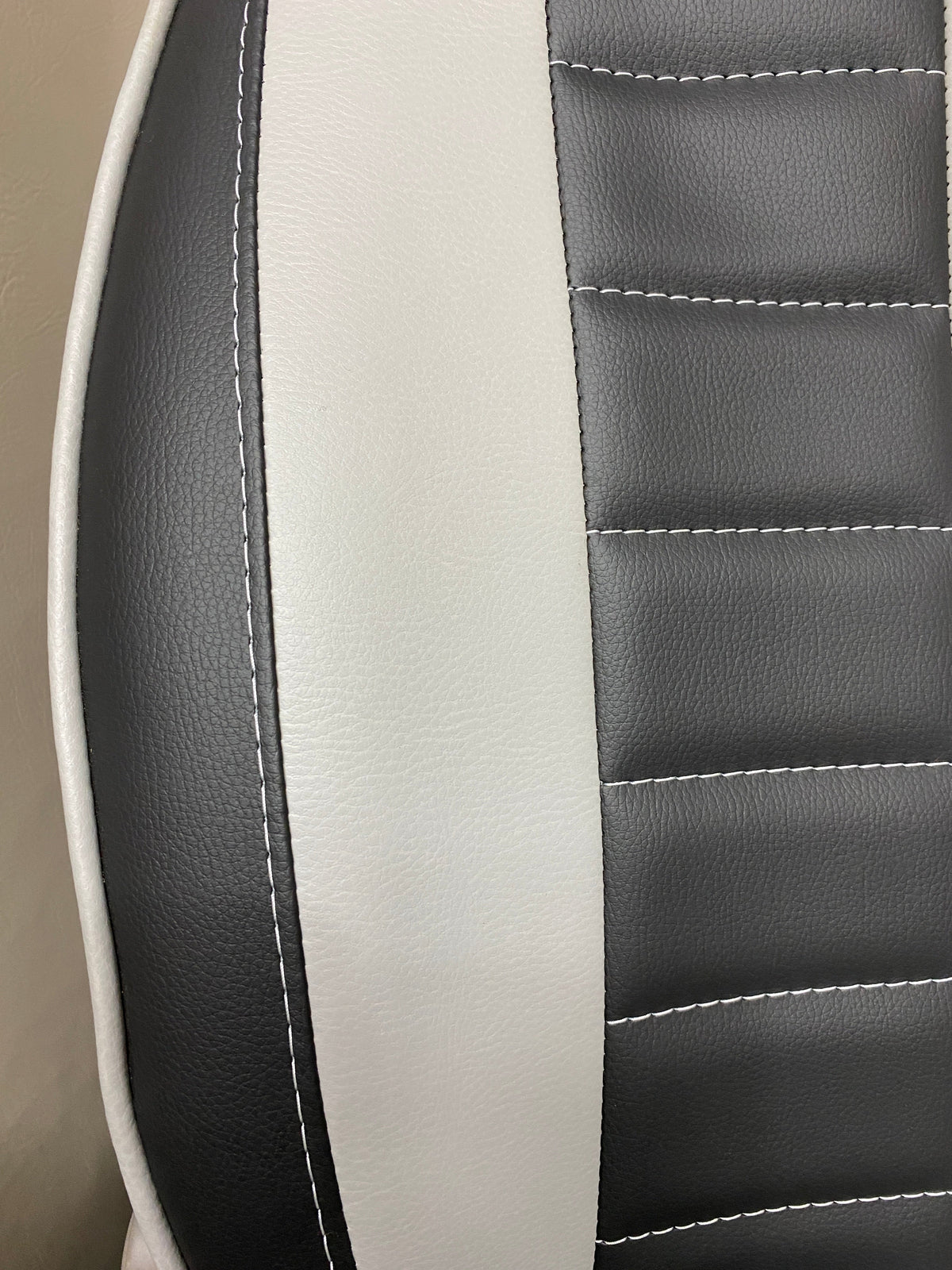 MK1 Replacement Swivel Captain Seat close-up, showing grey insert, horizontal wide stitching, and white piping on black leatherette.
