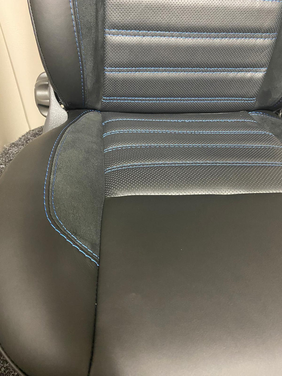 MK2 Replacement Swivel Captain Seat close-up of black Nappa leather seat, perforated centre panel, black Alcantara insert, and blue stitching.