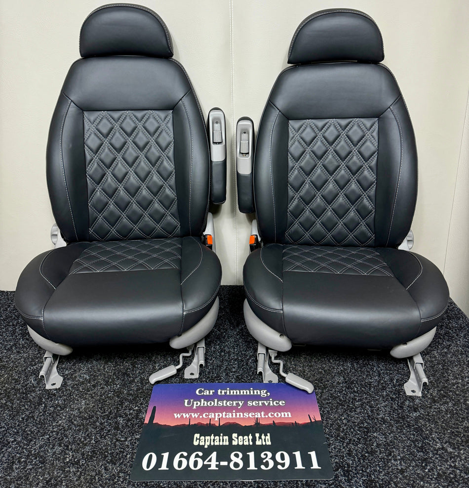MK2 Replacement Swivel Captain Seats in black real leather with mid-grey Bentley cross stitching, light grey plastic trim, and single armrests on each seat.