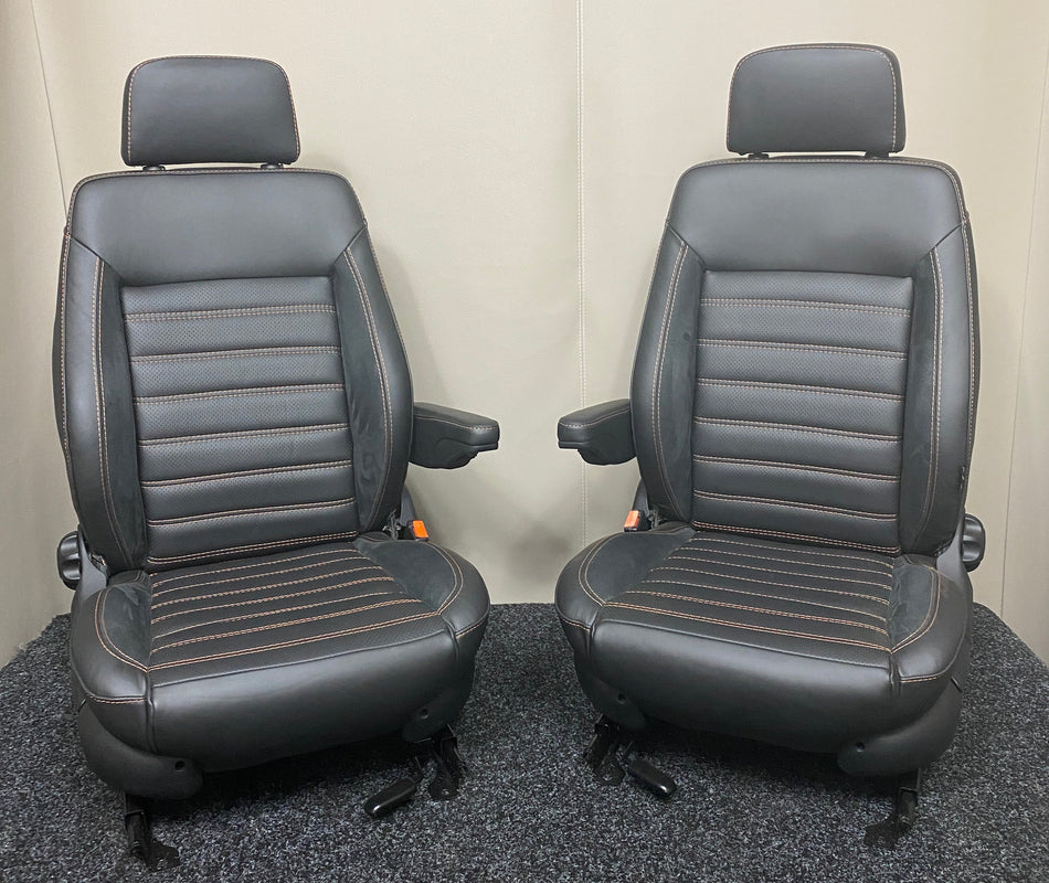MK3 Replacement Swivel Captain Seats in black real leather upholstery with Alcantara inserts and wide horizontal orange stitching, shown in full view.