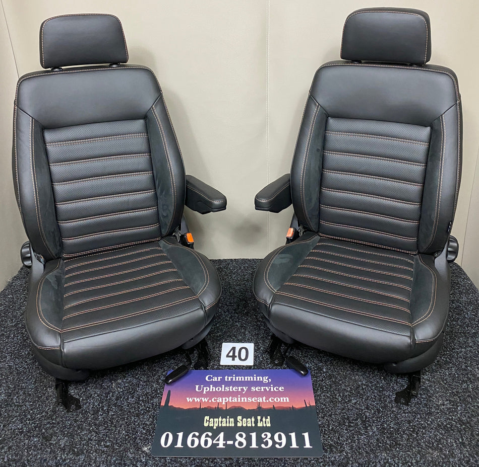 MK3 Replacement Swivel Captain Seats with black real leather, Alcantara inserts and wide horizontal orange stitching in full view.