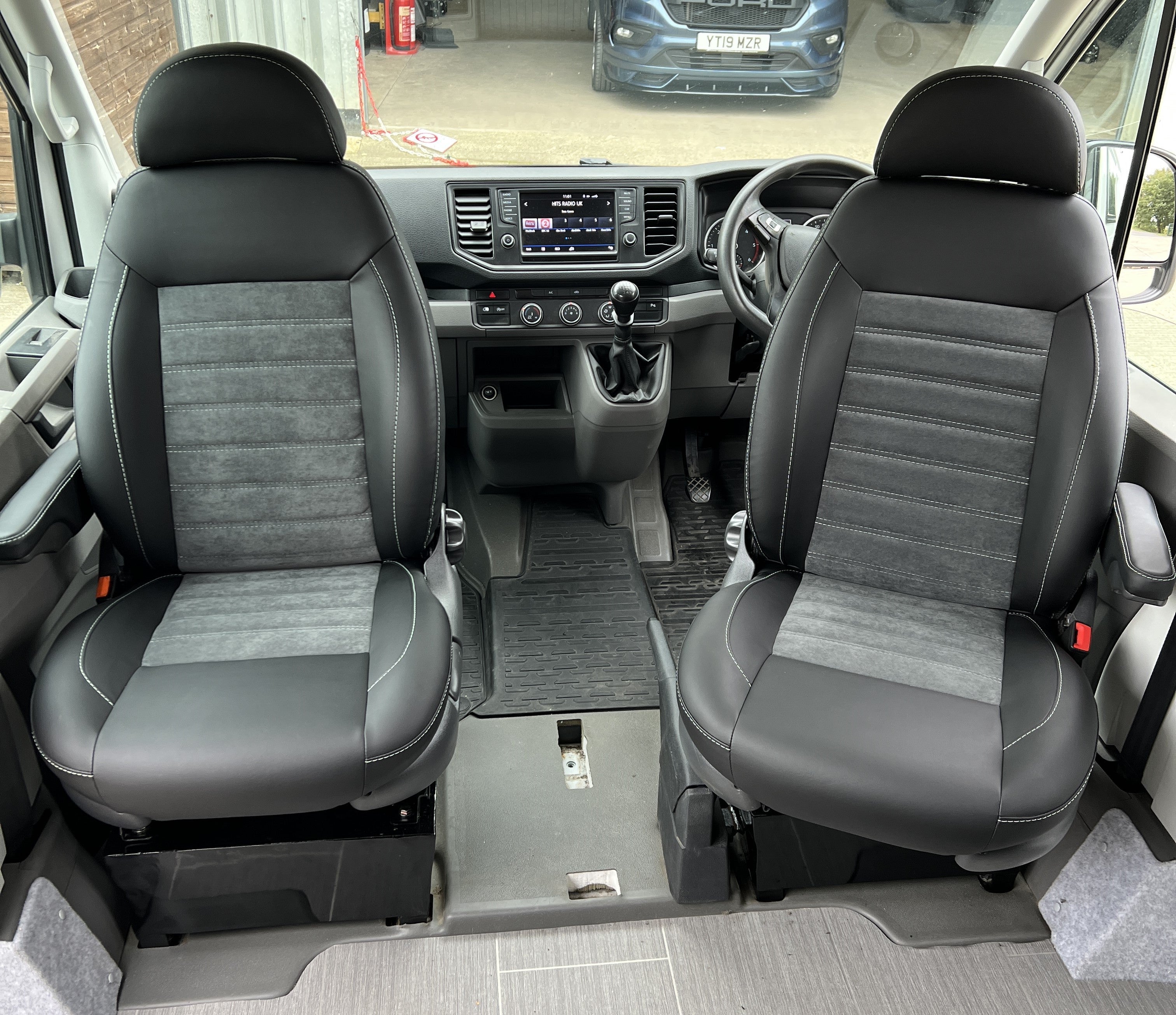 Pair of MK 2 Replacement Swivel Captain Seats in matt black leatherette with upgraded centre panels in dark grey faux suede with horizontal stitch pattern.