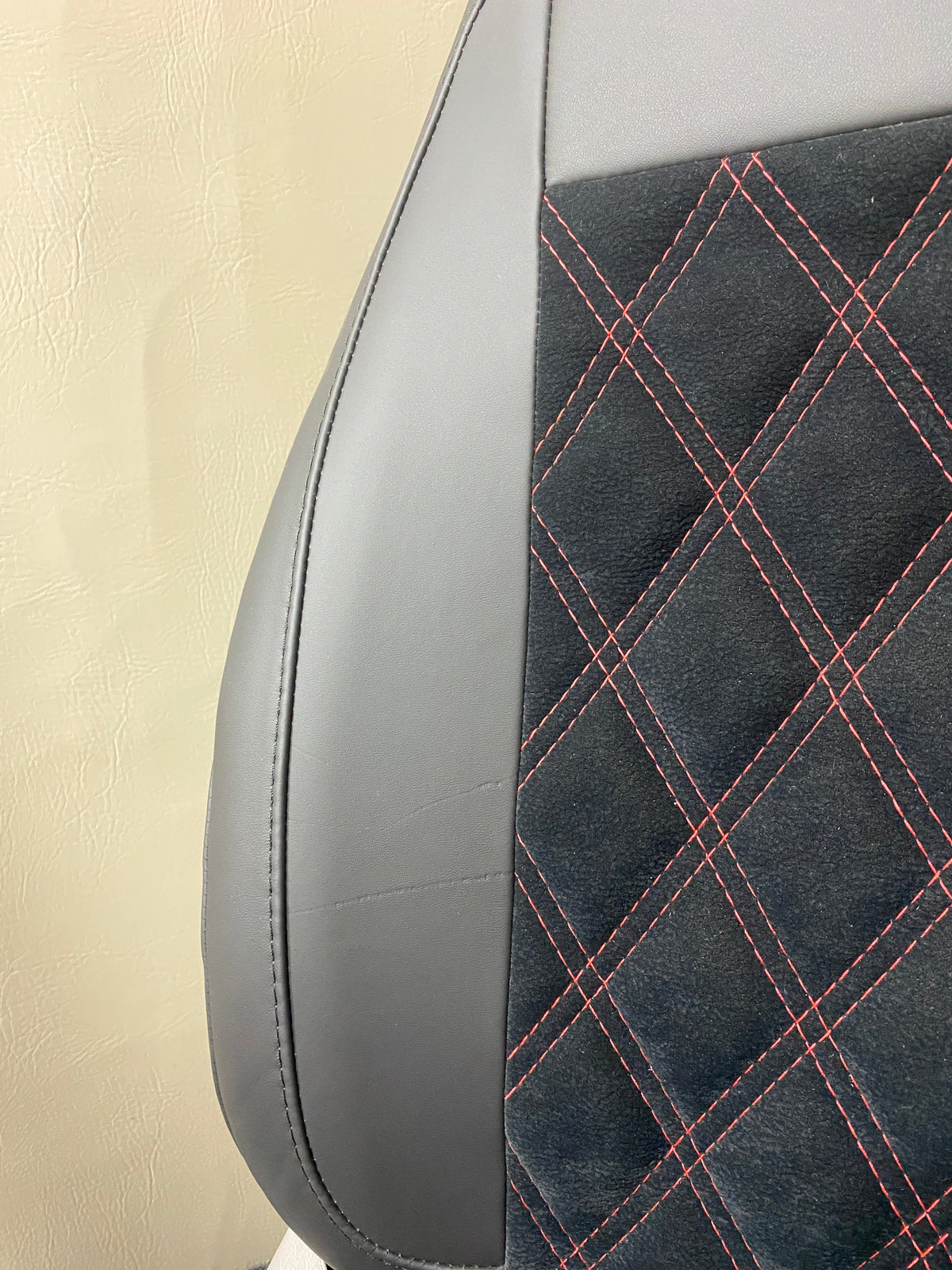 MK1 Replacement Captain Swivel Seat, close-up of side panel and black microfibre centre panel with red Bentley cross stitching.