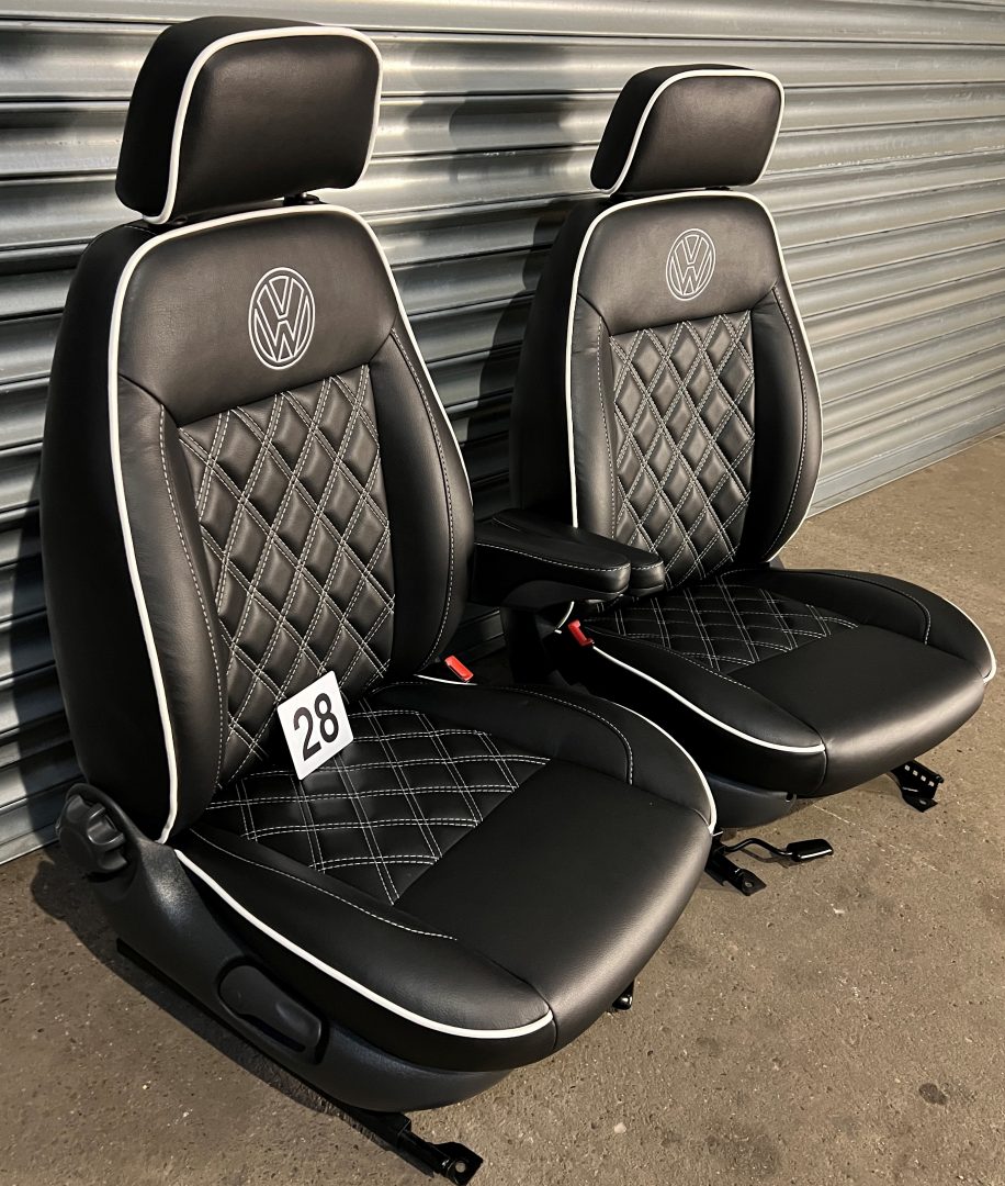 Pair of MK1 Swivel Replacement Captain Seats, angled view showing matt black leatherette with Bentley stitching, white piping, and VW logos.