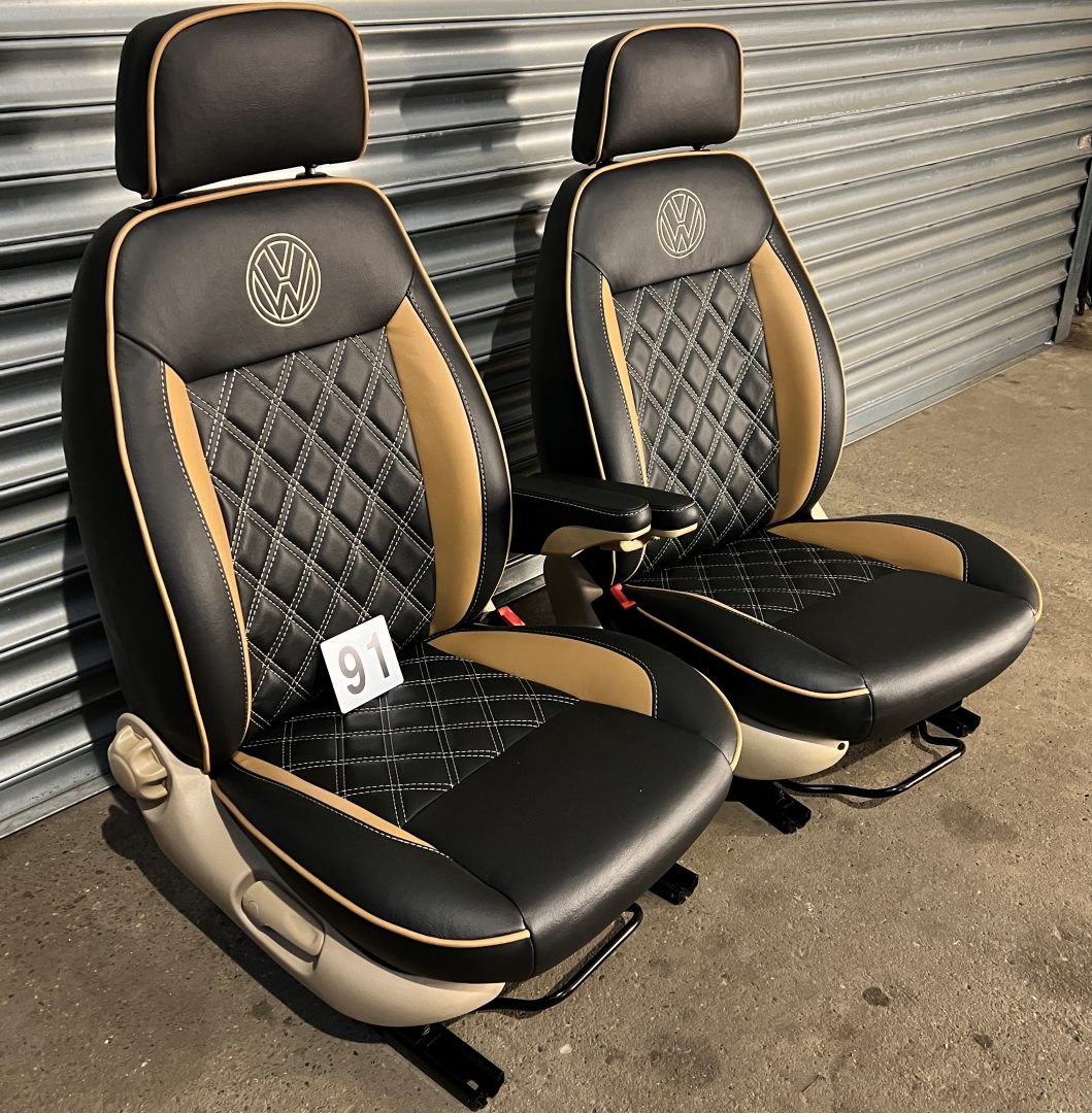 Pair of MK1 Swivel Replacement Captain Seats, angled view featuring matt black leatherette with Bentley stitch pattern, beige inserts, piping, and VW logos.