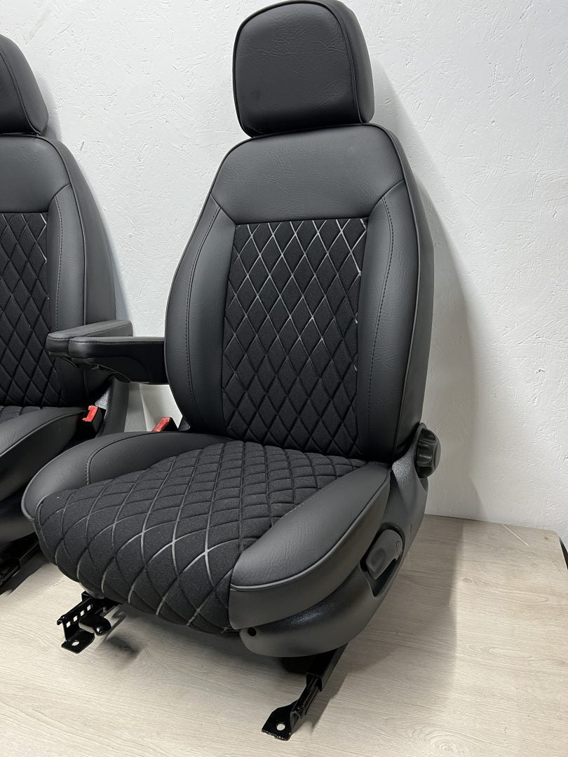 Pair of MK2 Swivel Replacement Captain Seats, angled view showing matt black leatherette, black faux centre panel, and one armrest per seat.