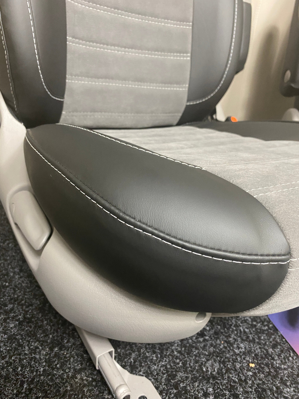 MK2 Swivel Replacement Captain Seat, close-up of the seat base with black leatherette side panel and light grey centre panel.