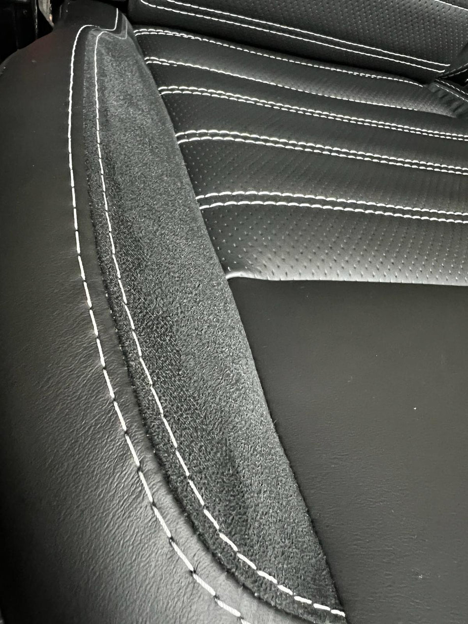 Pair of MK3 - Replacement Captain Swivel Seat, close-up of seat base, in black nappa leather with white horizontal stitching and Alcantara inserts.