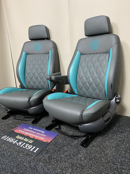 Pair of MK3 Replacement Captain Swivel Seats in grey real leather with teal inserts and horizontal teal stitch pattern, shown from a side angle. Features a VW logo embroidered in teal on the headrests, one armrest per seat.