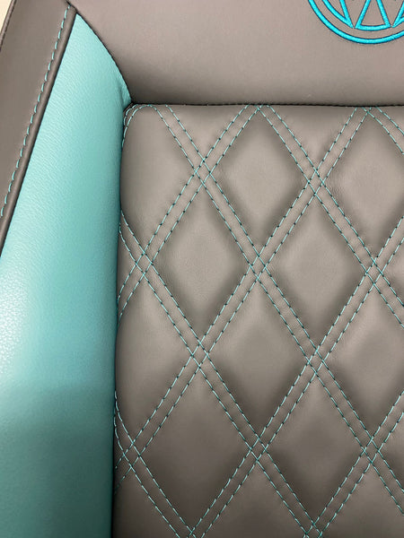 Close-up of MK3 Replacement Captain Swivel Seat featuring grey real leather upholstery with teal cross-stitch pattern, teal side inserts.