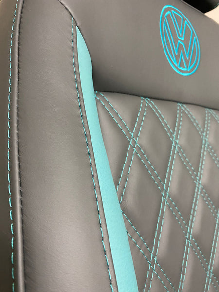 Detailed close-up of MK3 Replacement Captain Swivel Seat showcasing grey real leather, teal cross-stitching and side insert, with VW logo.