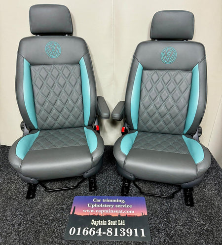Pair of MK3 Replacement Captain Swivel Seats in grey real leather with teal inserts and horizontal teal stitch pattern. Features a VW logo embroidered in teal on the headrests, one armrest per seat.