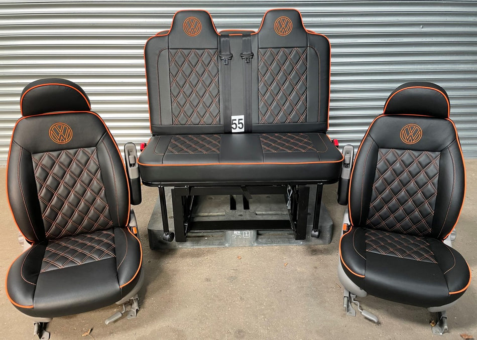 Pair of VW T4 T5 T6 Crafter Replacement Swivel Captain Seats and matching M1 Tested Gas Assisted Rock & Roll Bed in matt black leatherette with orange Bentley Cross stitching and VW logos.