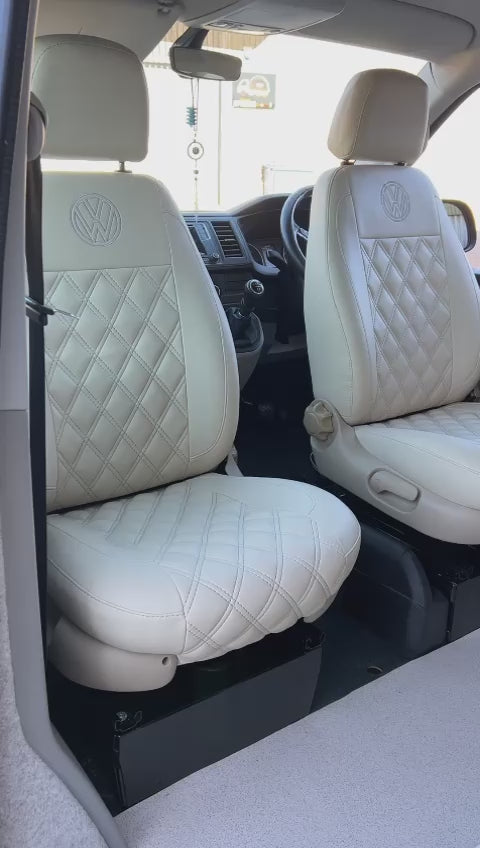 Rock and Roll bed M1 tested gas assisted and Pair of single swivel seats for T4 T5 T6 Traffic, Ford, Vivaro, Sprinter, Crafter made from light grey leatherette with Bentley stitching, installed in a vehicle.