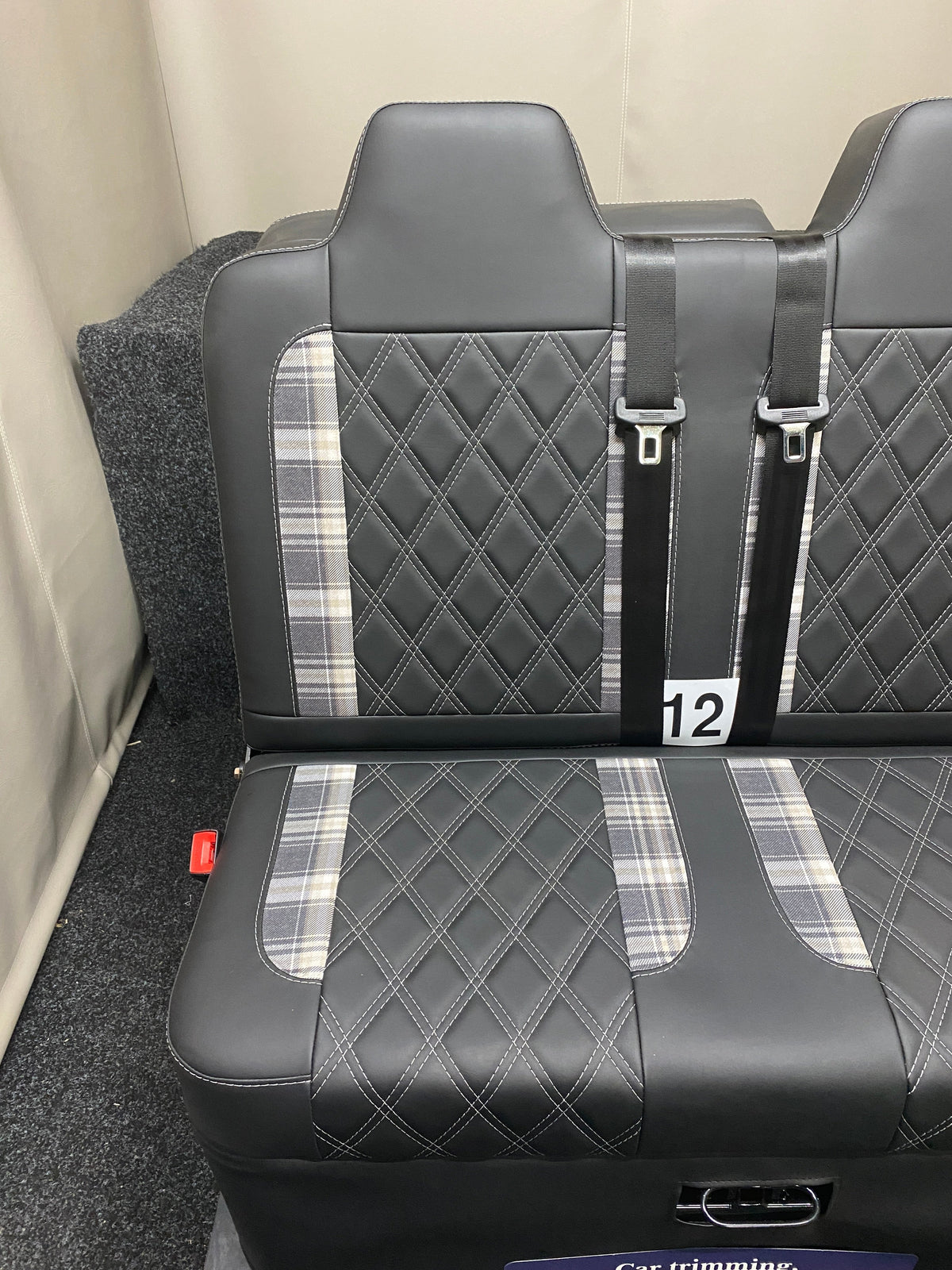 Rock and Roll Bed 3/4 Size M1 Legged Gas Assisted, with black leatherette upholstery, tartan inserts, and white Bentley stitching, shown with seatbelt detail.