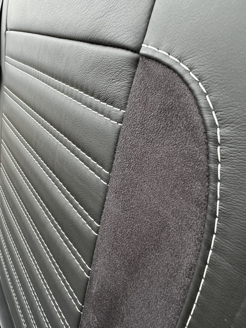 Rock and roll bed 3/4 width Deluxe Legless - 2 Seater - Real Leather M1 gas assisted, close-up of the backrest in black leather with black Alcantara insert and light grey horizontal stitching.
