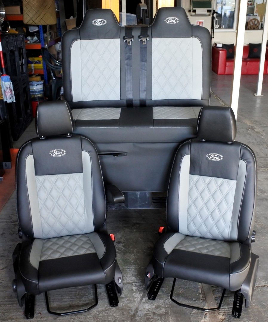 Rock and roll bed Ford Transit & Custom Seats Retrimming (FTC-09) in black leather with light grey centre panels, Bentley cross stitching and Ford logos.