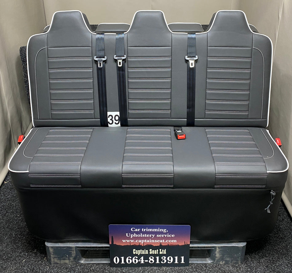 Rock and roll bed full size 3 seater M1 tested gas assisted reverse opening – front view of black leatherette seat with white piping and horizontal white stitching.