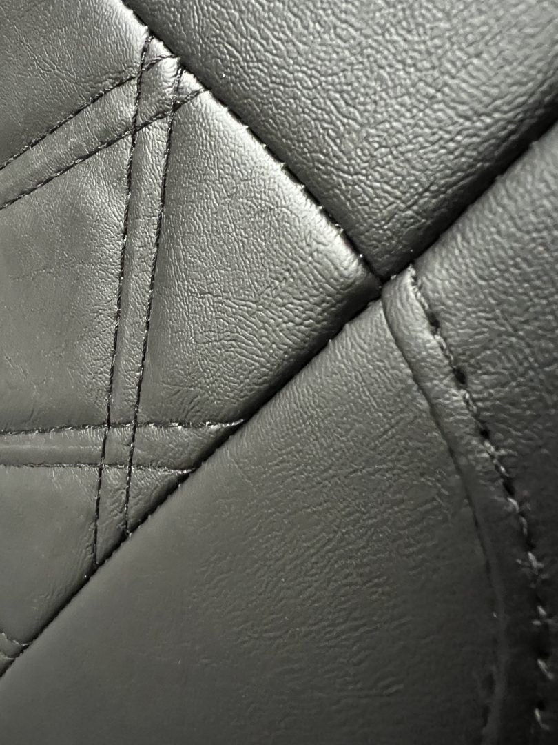 Rock and roll bed full width 3 seater M1 tested gas assisted, close-up of the black leatherette with black  Bentley stitching.