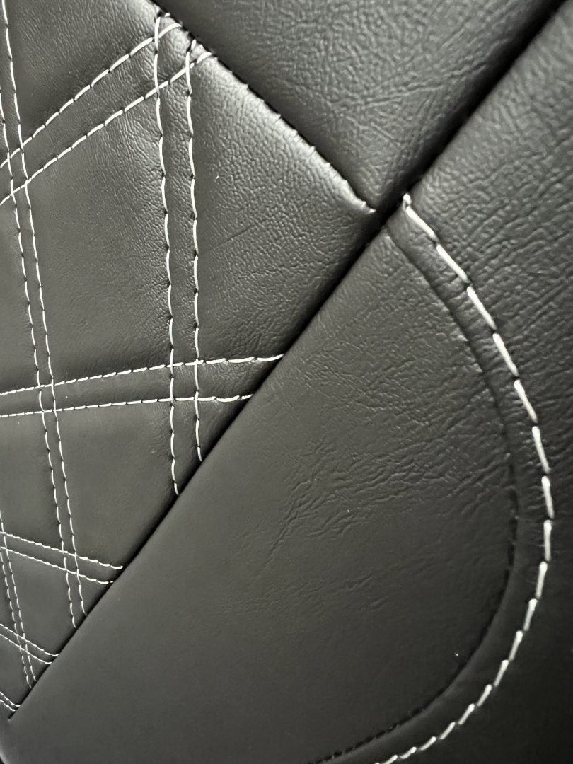 Rock and roll bed full width 3 seater M1 tested gas assisted, close-up of black leatherette with white Bentley stitching.