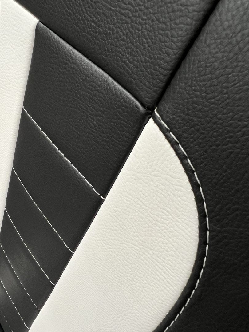 Rock and roll bed full width M1 tested gas assisted legged, close-up of black leatherette with white stitching and instert.