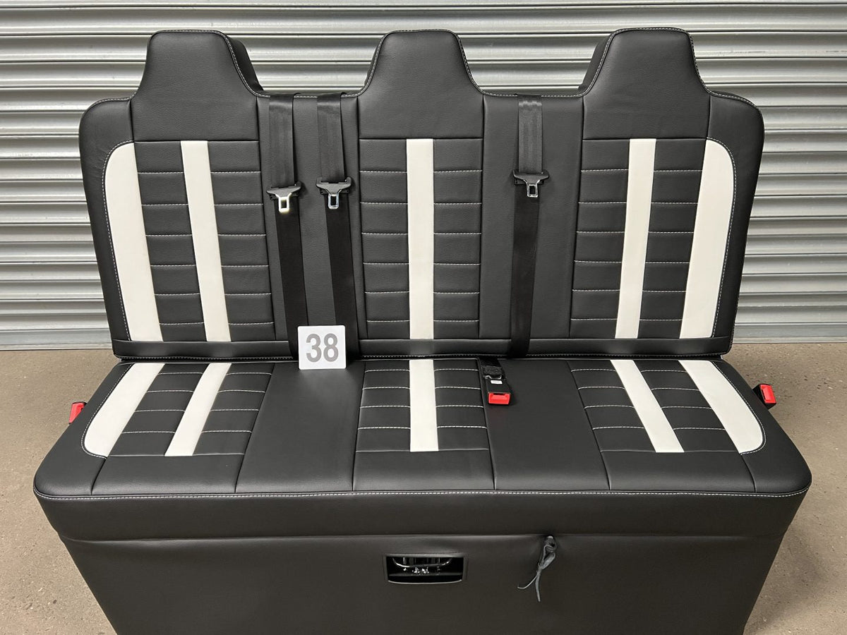 Rock and roll bed full width M1 tested gas assisted legged in black leatherette with white stitching, insterts and integrated seatbelts.