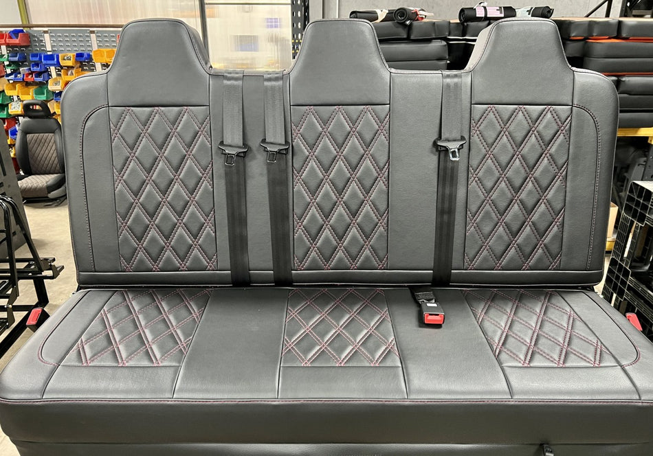 Rock and roll bed full width M1 tested gas assisted legged in black leather with Burgundy cross stitching and black seatbelts.
