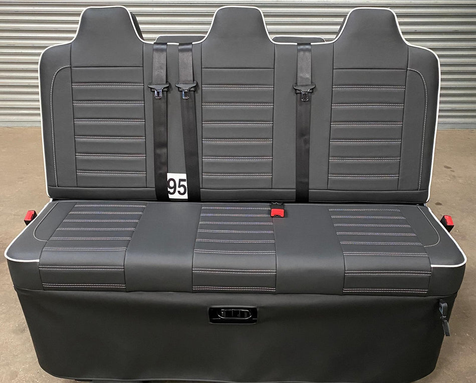 Rock and Roll Bed, Gas Assisted Full Width Legless M1, black leatherette with white piping, horizontal stitching, and integrated seatbelts.