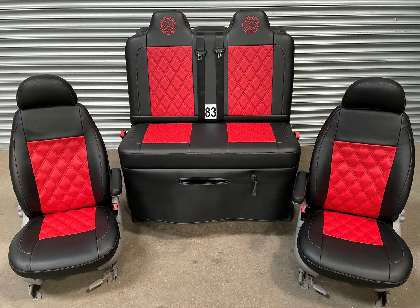 Rock and roll bed M1 tested gas assisted with matching single swivel front seats in matt black leatherette with red centre panels, Bentley cross red stitching and VW logos.