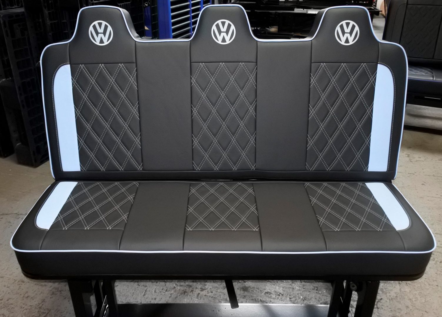 Rock and roll bed VW T4 T5 T6 3 seater in black upholstery with white inserts, stitching, piping and VW logos.