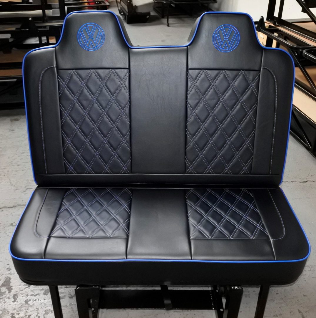 Rock and roll bed VW T4 T5 T6 M1 legged in black leatherette with blue piping, VW logos and white Bentley stitching.