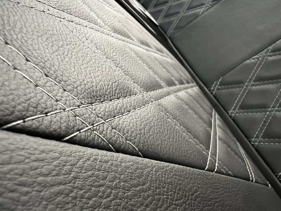 Rock & Roll Bed 3 seater Leisure gas assisted - 120cm, close-up of the black leatherette upholstery with grey Bentley cross stitch pattern.