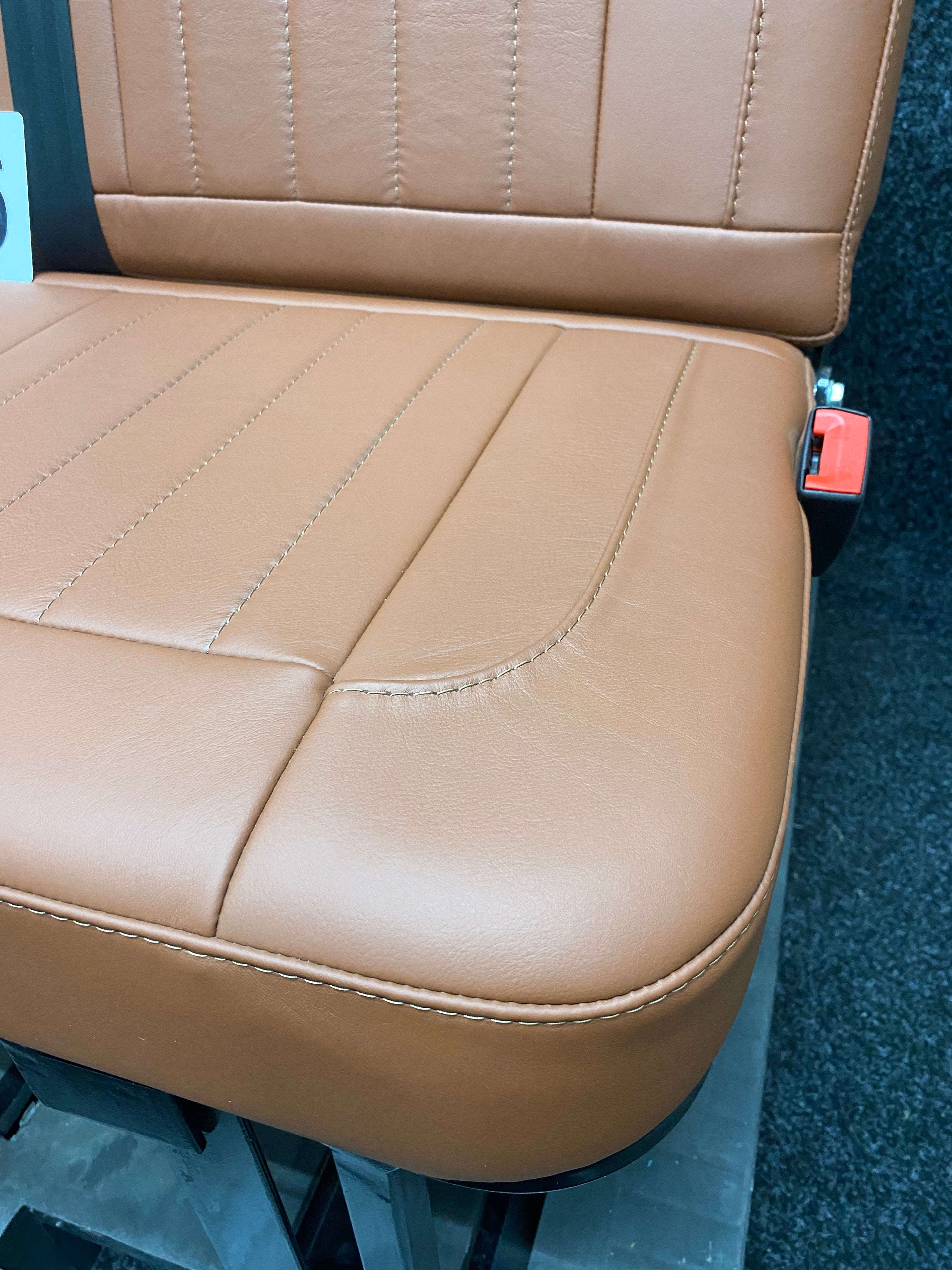 Rock & Roll Bed 3/4 M1 Tested 2 Seater, close-up of brown real leather seat base with vertical stitching and rounded corner detail.