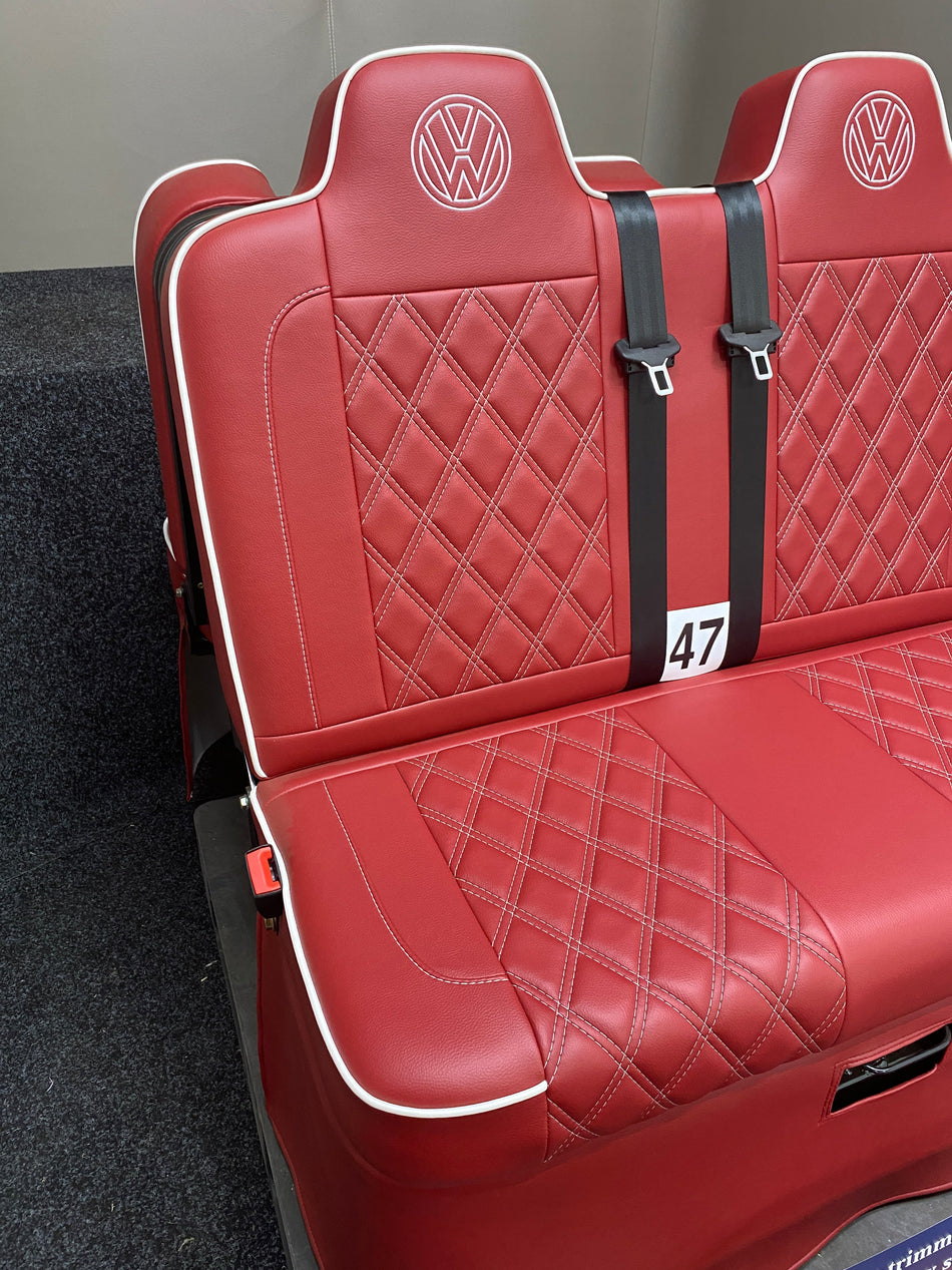 Rock & Roll Bed 3/4 M1 Tested 2 Seater, angled side view of red leatherette seat with full white stitchinging, white piping, and VW logos.