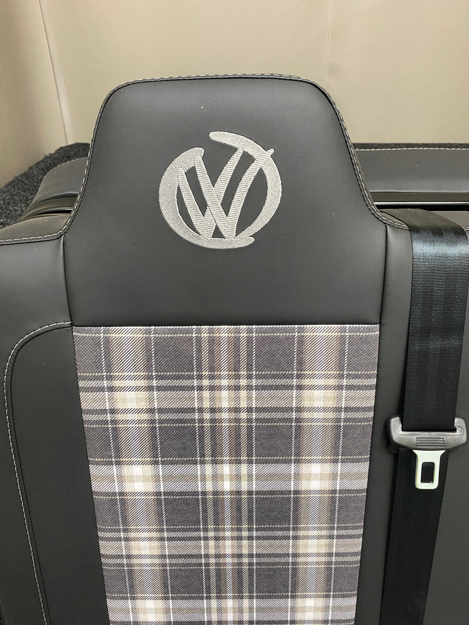 Rock & Roll Bed 3/4 M1 Tested 2 Seater, close-up of backrest with tartan centre panel, grey stitching, graffiti-style VW logo and integrated seatbelt.