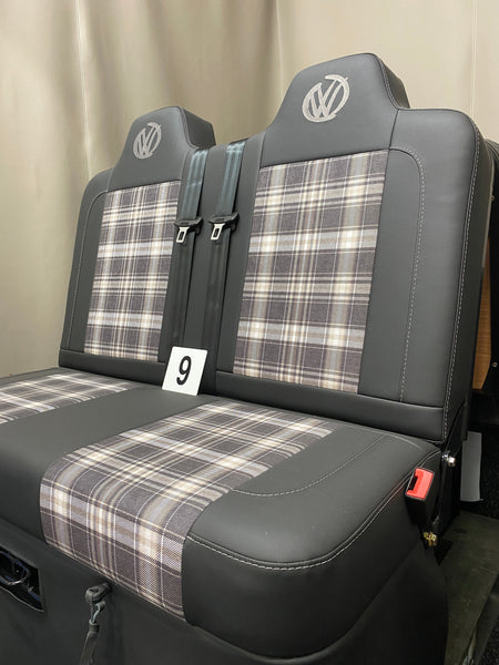 Rock & Roll Bed 3/4 M1 Tested 2 Seater, side view of black leatherette seat with tartan centre panels, grey stitching, VW graffiti logos and integrated seatbelts.