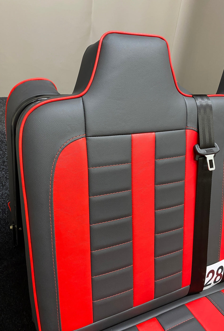 Rock & Roll Bed M1 Tested Full Width Gas Assisted, angled view of backrest showing red centre panel, red piping, and horizontal red stitching on black leatherette.