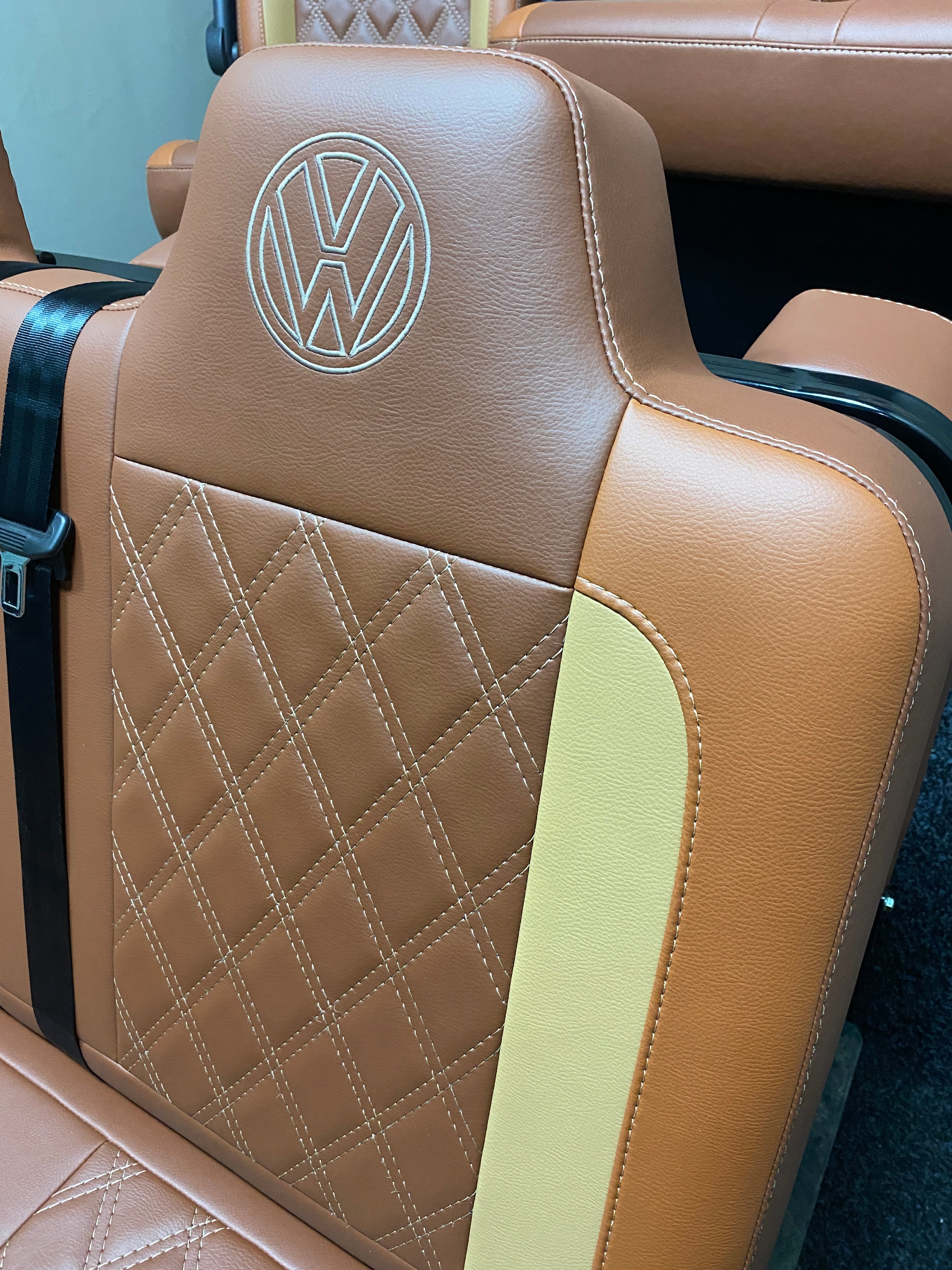Rock & Roll Bed VW T4 T5 T6 Crafter, close-up of upper backrest with VW logo embroidery and Bentley stitched tan and toffee leatherette.