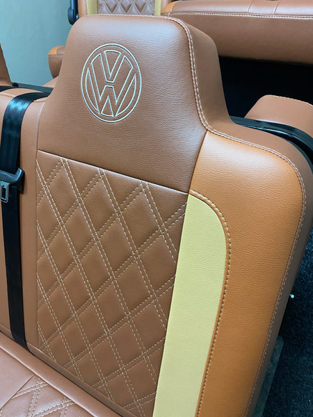 Rock & Roll Bed VW T4 T5 T6 Crafter, close-up of upper backrest with VW logo embroidery and Bentley stitched tan and toffee leatherette.