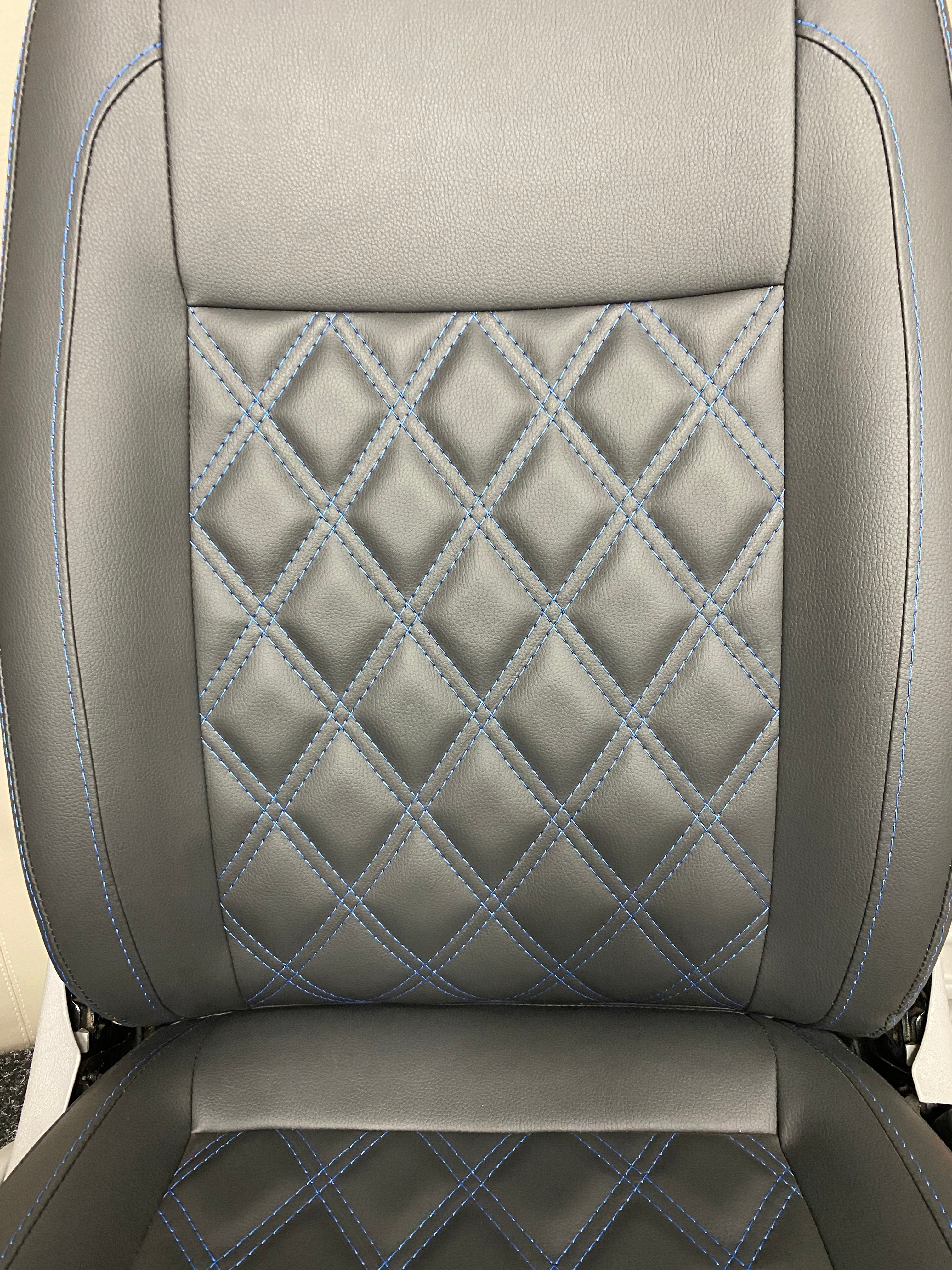 VW Factory Front T5 T6 Seat close-up of the backrest, highlighting the blue Bentley cross stitching on black leatherette upholstery.