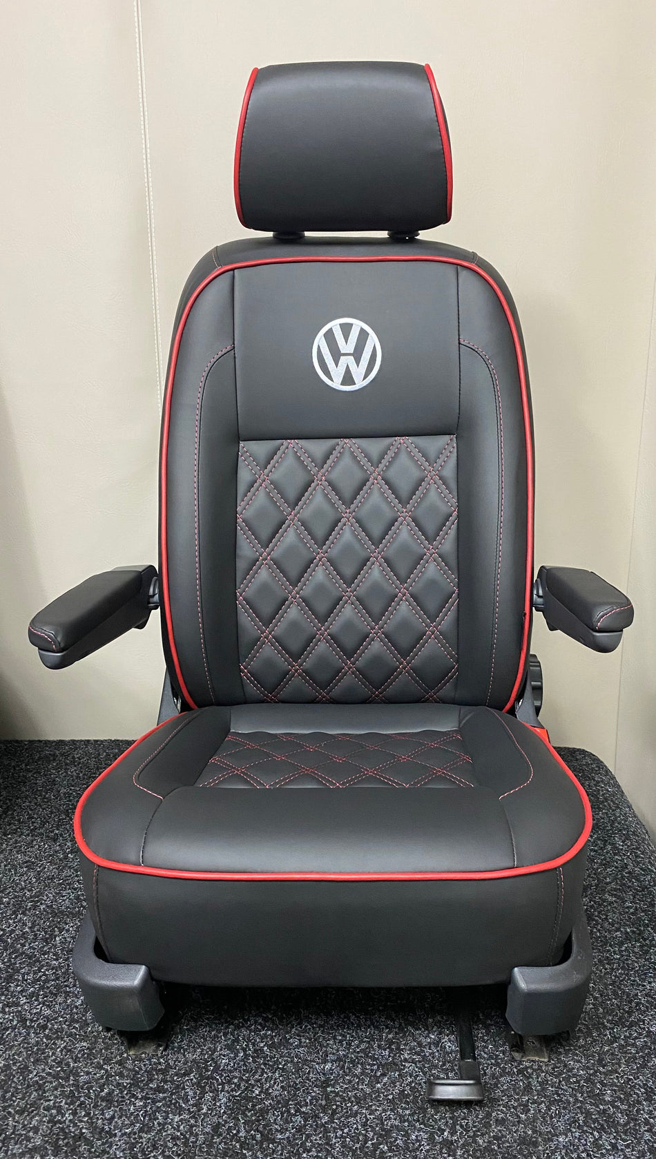VW Factory Driver Seat T5 T6, front view of black leatherette seat with white VW logo, red Bentley stitching, dark red piping, and both armrests.